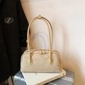 Chic beige suede baguette bag with double zippers and slim straps shown on travel books - Apricot