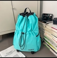 Gros plan du sac à dos en nylon bleu ciel avec logo KEMIBAG dans un cadre de vie quotidien - Bleu Lac