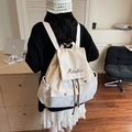Mochila de lona color crema con solapa superior, bordado de marca y detalle de cordón - Blanco Roto