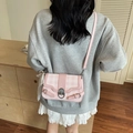 Pink checkered crossbody bag with silver buckle and pearl lace charm on grey sweater - Pink