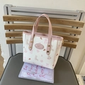 Bolso cubo rosa y blanco con estampados de dibujos animados y asas sobre una silla - Rosa