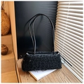 Detail of leopard print shoulder bag with drawstring ribbons on a decorative book - Black