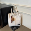 Creamy white canvas tote bag featuring a cute plush bear charm and fashion logo tag - Beige With Charm