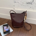 Deep brown woven bucket bag with vintage beaded tassel and slim woven shoulder strap - Brown