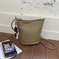 Olive green woven bucket bag with beaded charm and thin shoulder strap - Elm Green