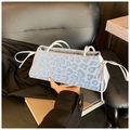 Detail of light blue leopard print tote with white bow accents and top handle - Blue