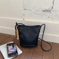 Detail of black woven bucket bag with smooth faux leather texture and wooden bead charm - Black