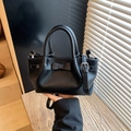 Minimalist black leather bucket bag with bow detail and adjustable shoulder strap - Black