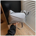 Detail of silver grain leather crossbody bag featuring geometric puzzle flap design - Silver