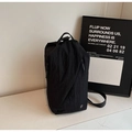 Close-up of black nylon multi-functional bag with asymmetric zipper and silver logo detail - Black