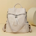 Minimalist beige PU leather backpack with tassel detail and adjustable straps for women - Off White