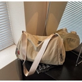 Primer plano de bolsa de viaje de nailon beige con cremallera lateral en mesa - Caqui