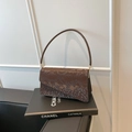 Dark brown snake pattern handbag with gold hardware displayed on a decorative prop - Style Two (Asymmetric Flap) / Brown