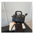 Detail of a mini black lychee leather pillow bag with silver zipper and long strap - Black