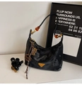 Detailed close-up of a black marble texture handbag with golden triangle logo and beads - Black