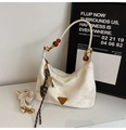 Detail of cream nylon underarm bag with amber beaded handle and gold abacus charm - Off White