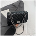 Detail of black quilted chain bag featuring silver hardware and a turn-lock closure - Black