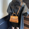 Bruine vintage handtas met bloemenreliëf en zilverkleurige metalen draaisluiting - Bruin