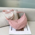Pink nylon crescent crossbody bag with adjustable strap on a minimalist sofa - Pink