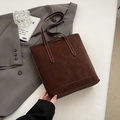 Dark brown suede tote bag with minimalist vertical profile on a gray suit jacket - Brown No Pendant