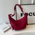 Dark red crescent dumpling bag in durable nylon with woven tassel details and strap - Red