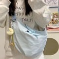 Light blue nylon crescent crossbody bag featuring a yellow moon charm and beaded detail - Blue with Charm