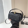 Elegant black crossbody bag with embossed floral texture and gold hardware detail - Black