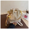 Detalle de bolso saco de jacquard beige con cordón ajustable y colgante de oso dorado - Blanco Roto