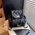 Sac à dos matelassé noir avec chaînes dorées et fermoir sur fond de blazer blanc - Noir