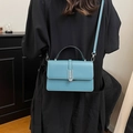 Blue crossbody bag for women with contrast stitching and metal buckle shown on model - Green