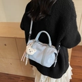 Light blue faux leather pillow bag with bear charm shown on model back view - Blue