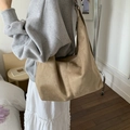 Minimalist camel suede tote bag with zipper closure shown on shoulder for daily commute - Khaki