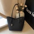 Retro black woven leather tote bag with heart pendant in a stylish home setting - Black