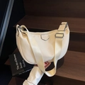 Schicke cremeweiße Nylon-Hobo-Halbmondtasche mit breitem Gurt auf einer Holztreppe - Gebrochenes Weiß