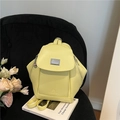 Pale yellow fashion mini backpack in synthetic leather with geometric design on black chair - Yellow
