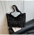 Close-up of black nylon tote bag with white star patterns and large decorative bow detail - Black
