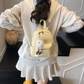 Mini light yellow backpack with plush pendant worn by model in casual grey outfit - Yellow with Pendant