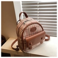 Vue détaillée du mini sac à dos à carreaux roses avec détails en cuir sur un rebord - Rose