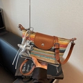 Rainbow woven crossbody dumpling bag with brown leather flap and trendy silver charms - Multicolor With Charm
