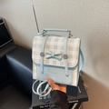 Sac bandoulière à carreaux bleus avec nœud et poignée sur un livre de style chic - Bleu