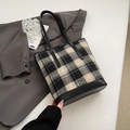Sac seau en laine à carreaux noir et blanc avec anses en cuir sur une veste grise - Grille Noire Sans Pendentif