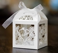 Macro shot of white laser-cut wedding favor box with Love heart and silk bow detail - White