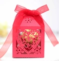 Close-up of red laser-cut wedding favor box with LOVE heart pattern and silk ribbon - Pearlescent Red