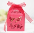 Nahaufnahme der rosa lasergeschnittenen Schachtel mit Schmetterlingen und rotem Band - Perlrot