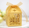Macro di una scatola di caramelle dorata traforata con trama perlata e fiocco in organza - Oro