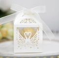 Close-up of white laser-cut wedding favor box featuring swan heart design and organza ribbon - Ivory
