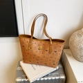 Brown tote bag featuring cartoon bear and bow prints with a gold brand logo plate - Brown No Pendant