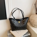 Chic black tote bag with silver bear patterns and golden logo on a litchi leather surface - Black without Pendant