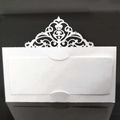 Macro shot of white laser-cut seat card with elegant hollow pattern for wedding decor - White