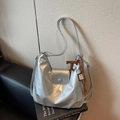Sac hobo argenté métallisé avec large bandoulière et pendentif à glands marron sur livre - Taille unique / Argent